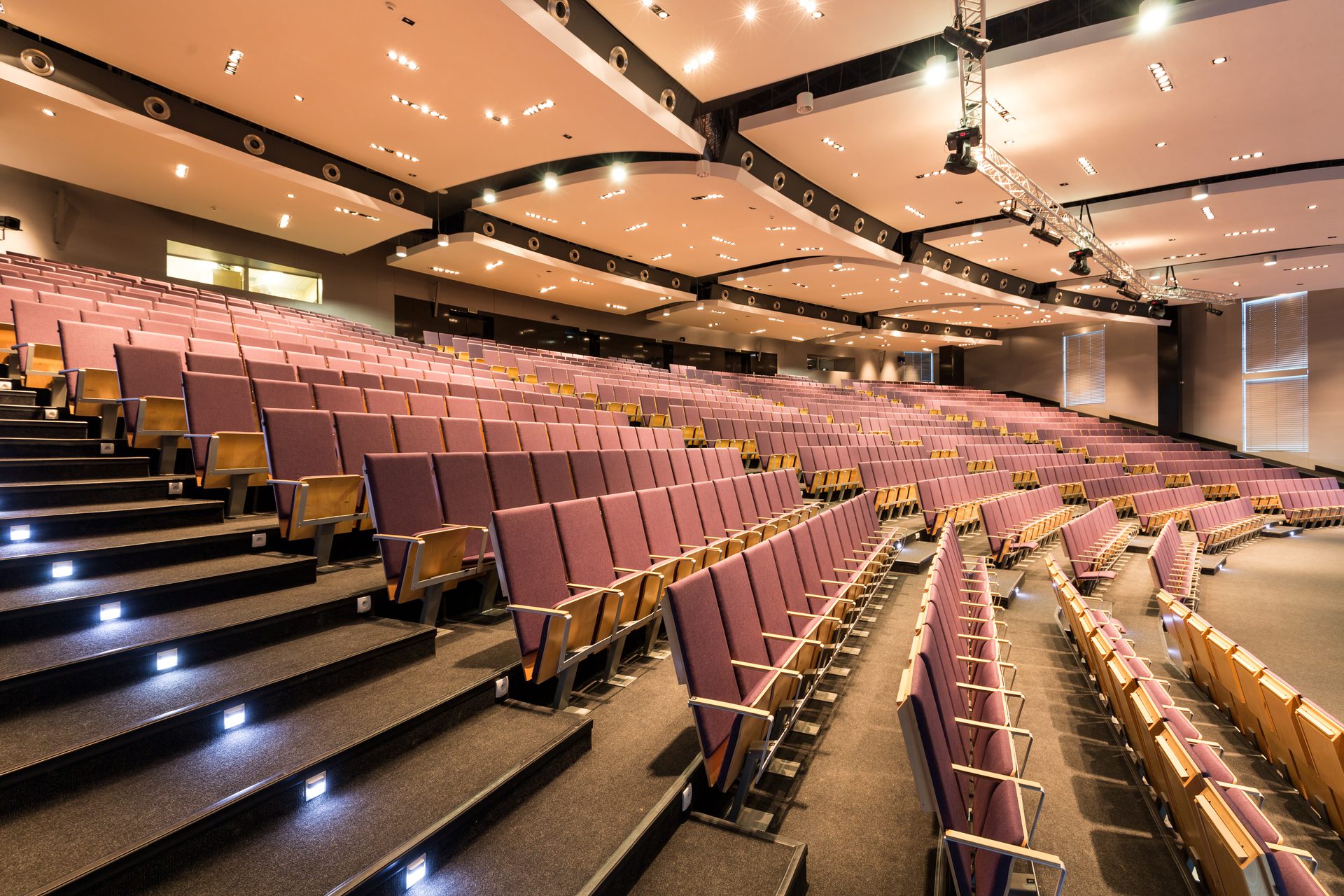 Spacious Auditorium with Rows of Chairs and Stairs